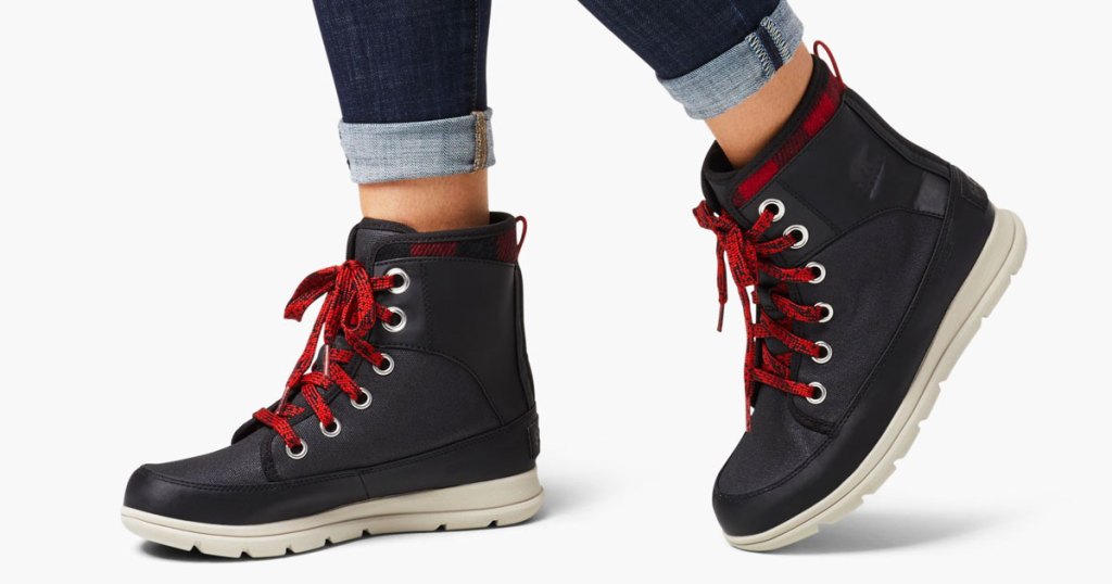 woman in rolled up skinny jeans with pair of black boots with red laces