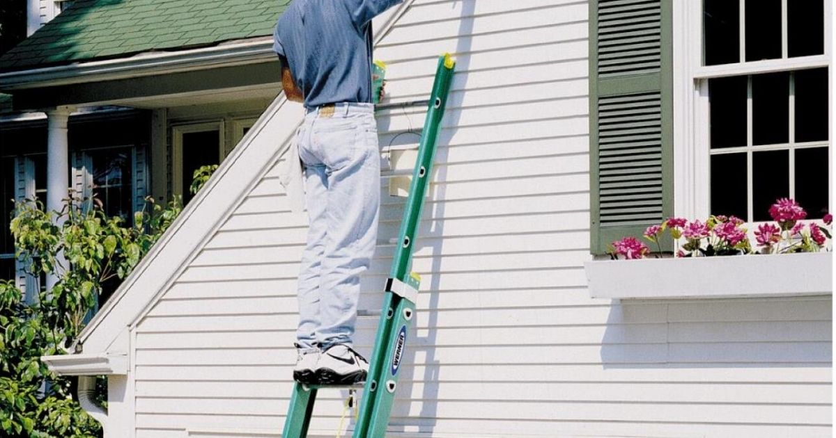 Man on Werner 20-ft. Extension Ladder against a white house