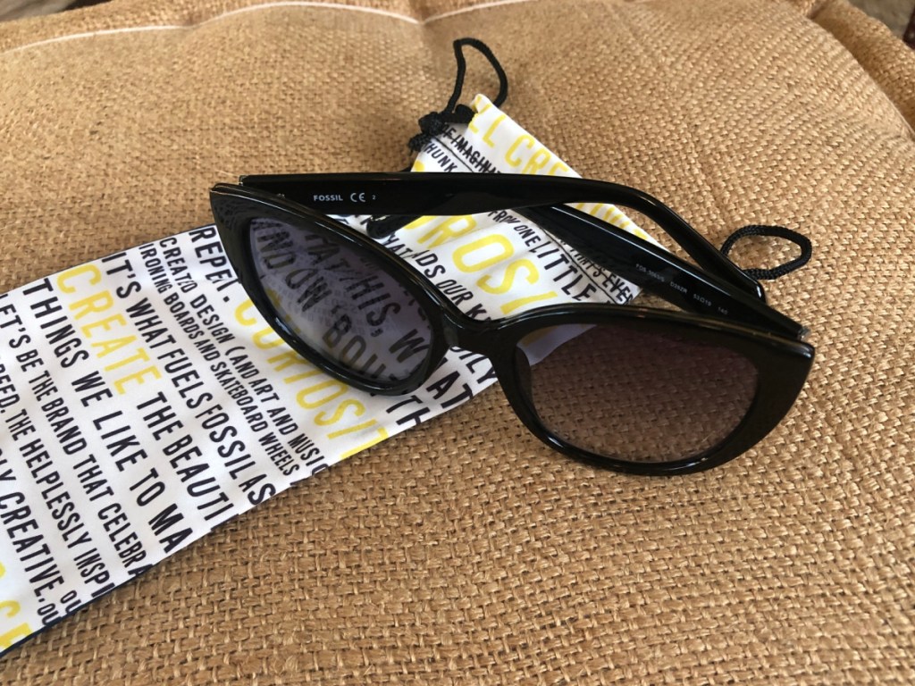 women's fossil sunglasses folded sitting on a fossil dustbag