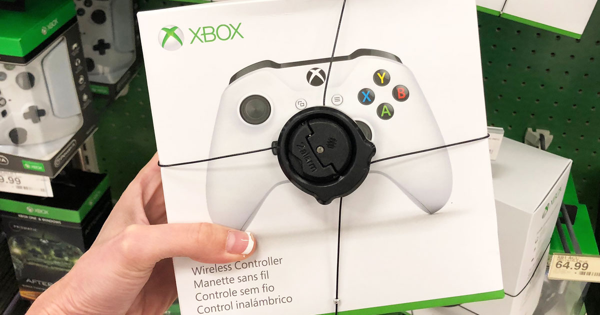 woman holding the box for a white xbox controller withe anti-theft cables around it