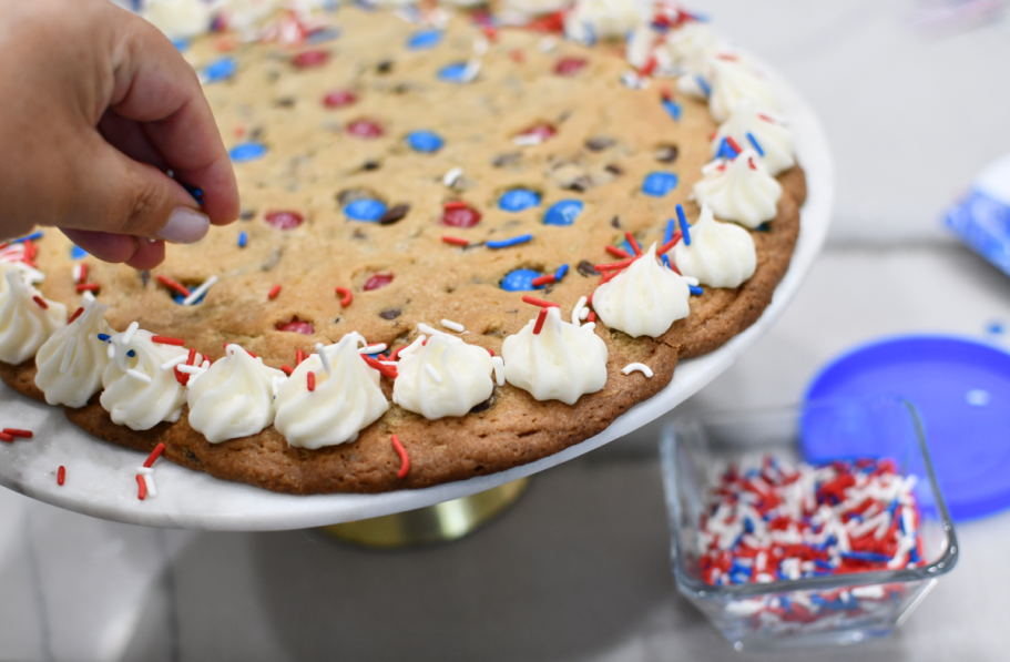 adding sprinkles to cookie cake