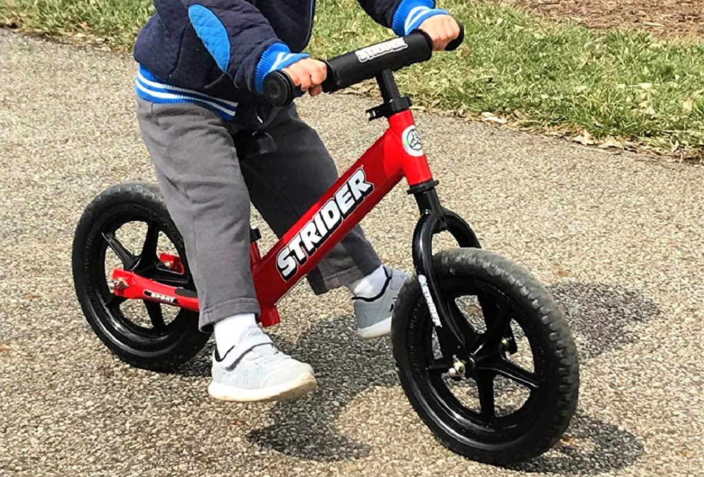 boy riding Strider 12 Balance Bike in red
