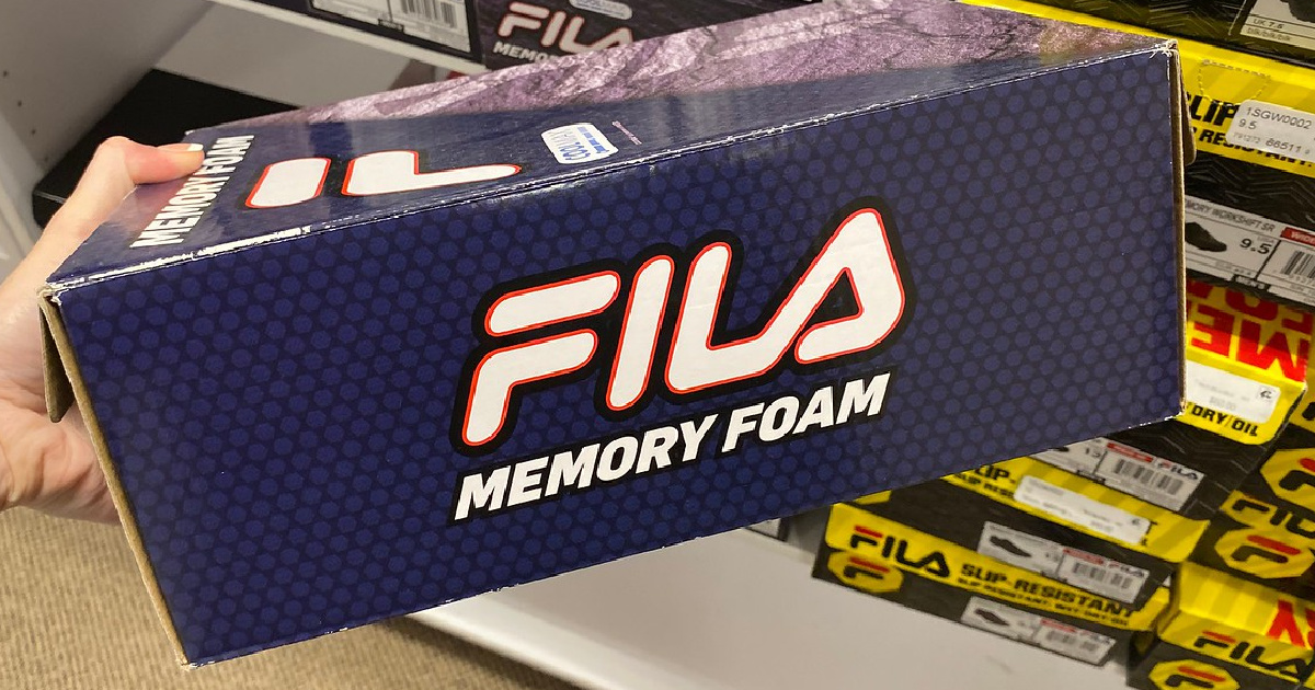 hand holding shoe box labeled FILA in store