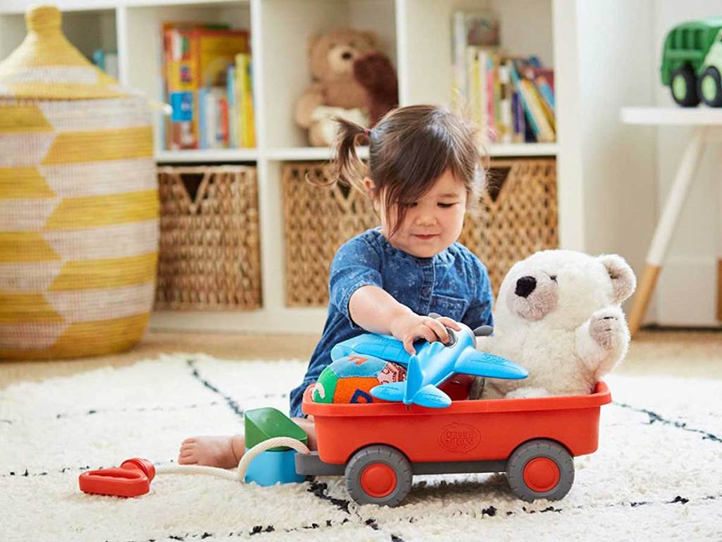 child playing with toys in a wagon