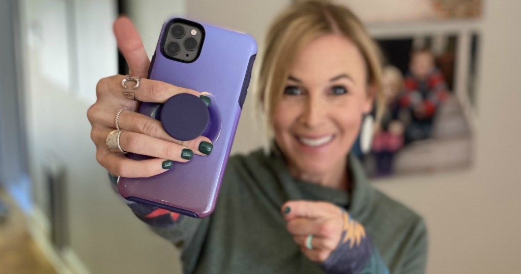 woman holding up phone with popsocket after reading joybird reviews