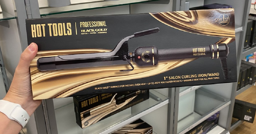 hand holding box with curling iron in it