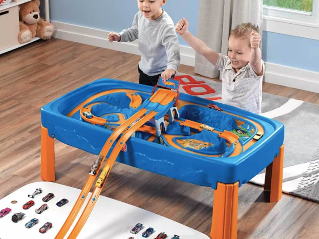 boys playing with race car and track table