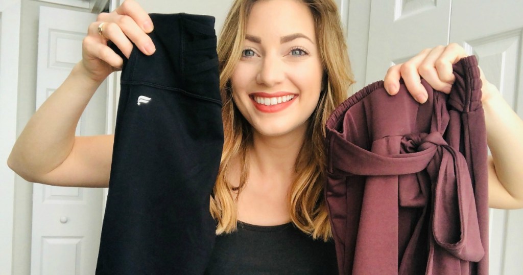 woman holding two pairs of pants