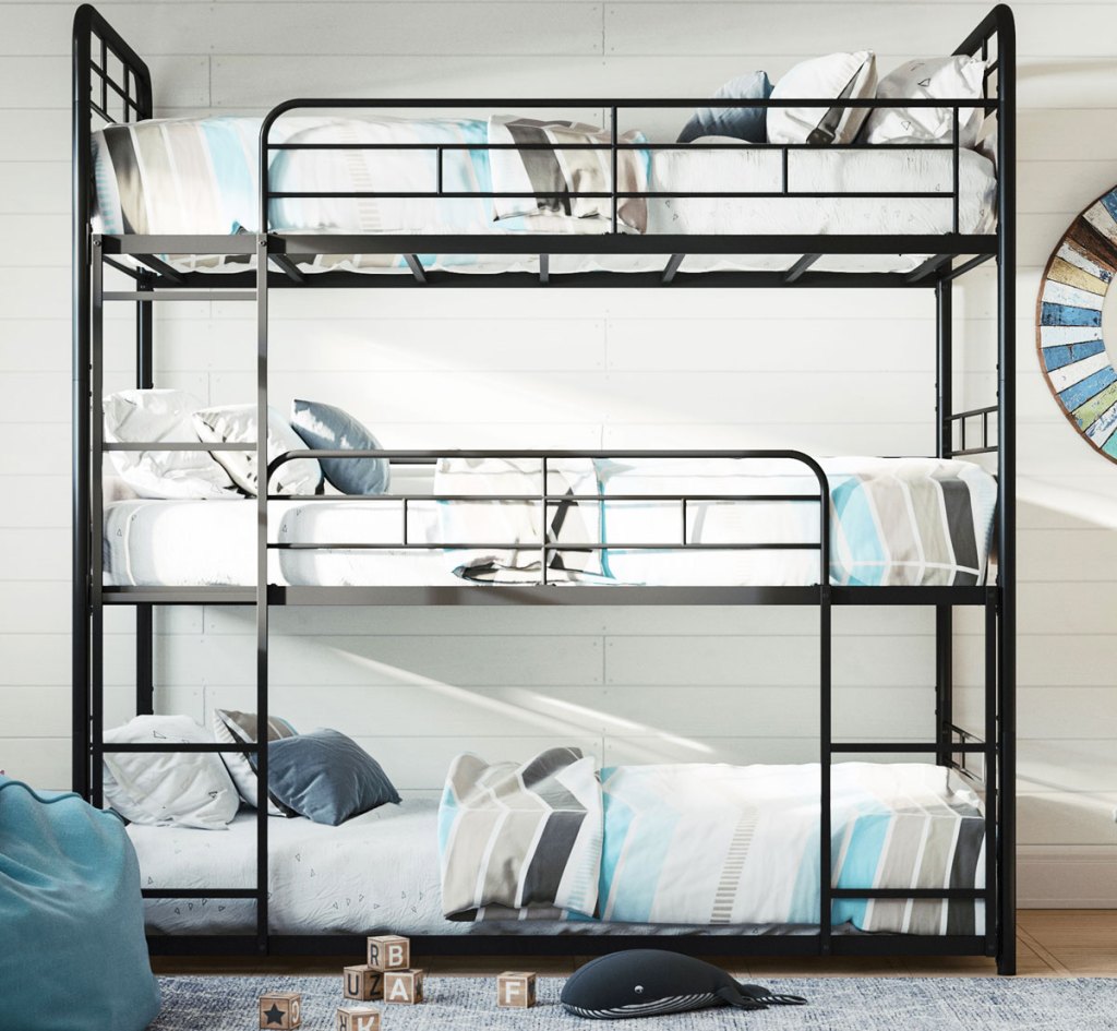 metal triple bunk bed against white wall in a kids room