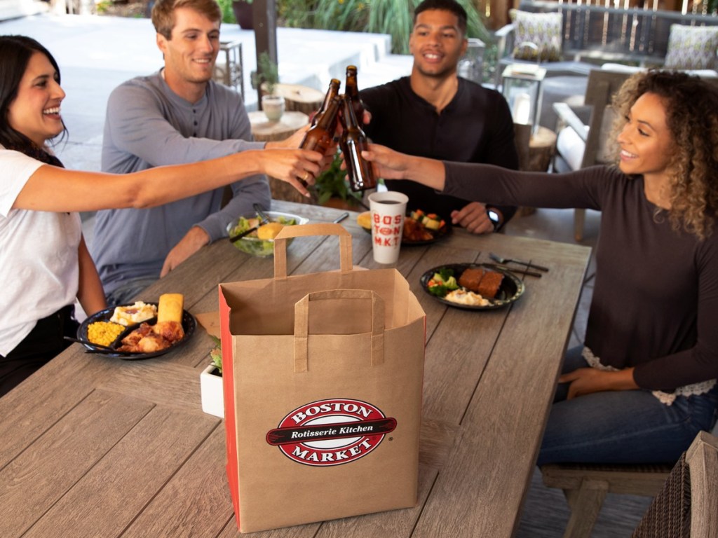 several people around picnic table with food and beer