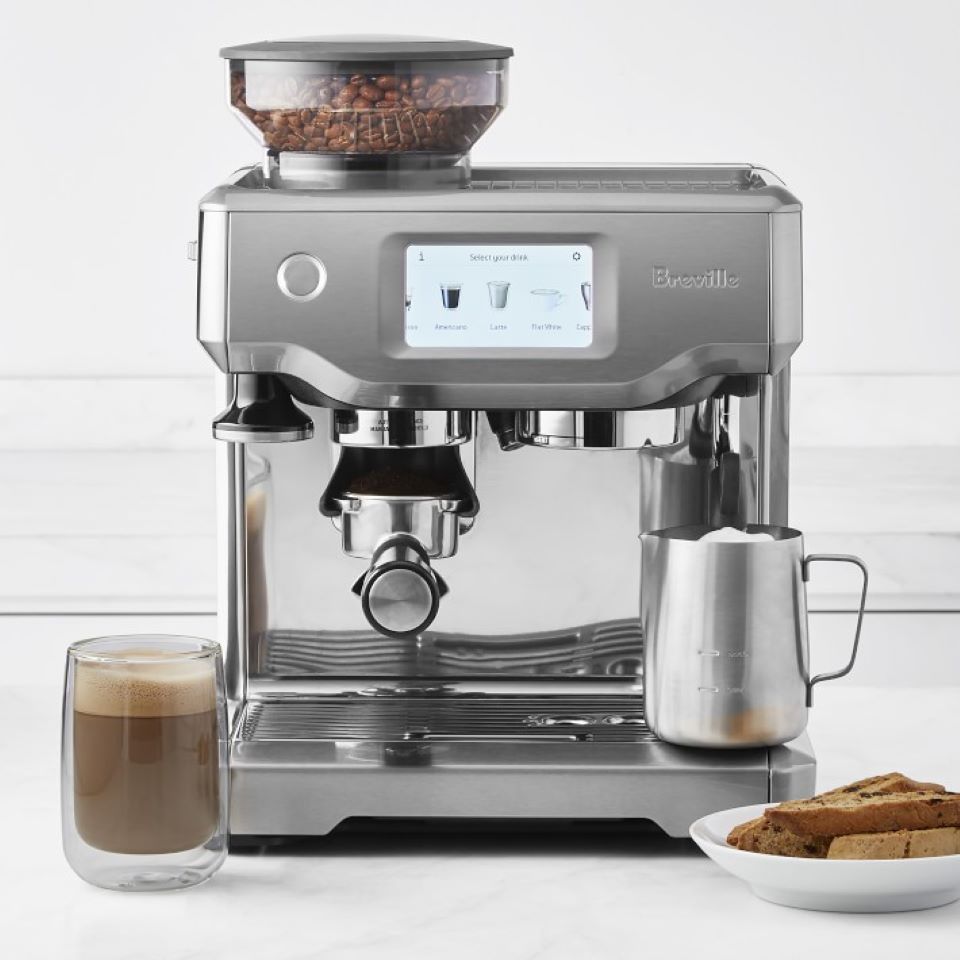 espreso maker on the table with coffee next to it