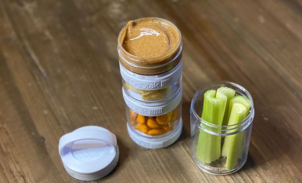 Celery and almond butter in snack containers on a table