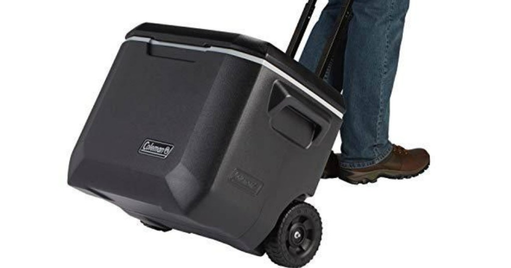 man pulling a black rolling cooler