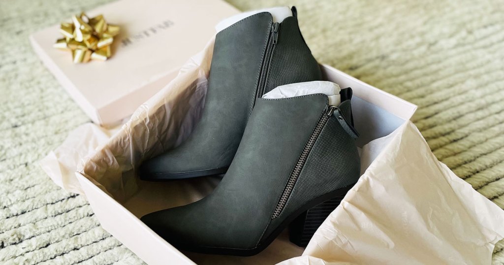 pair of grey booties in a pink shoe box