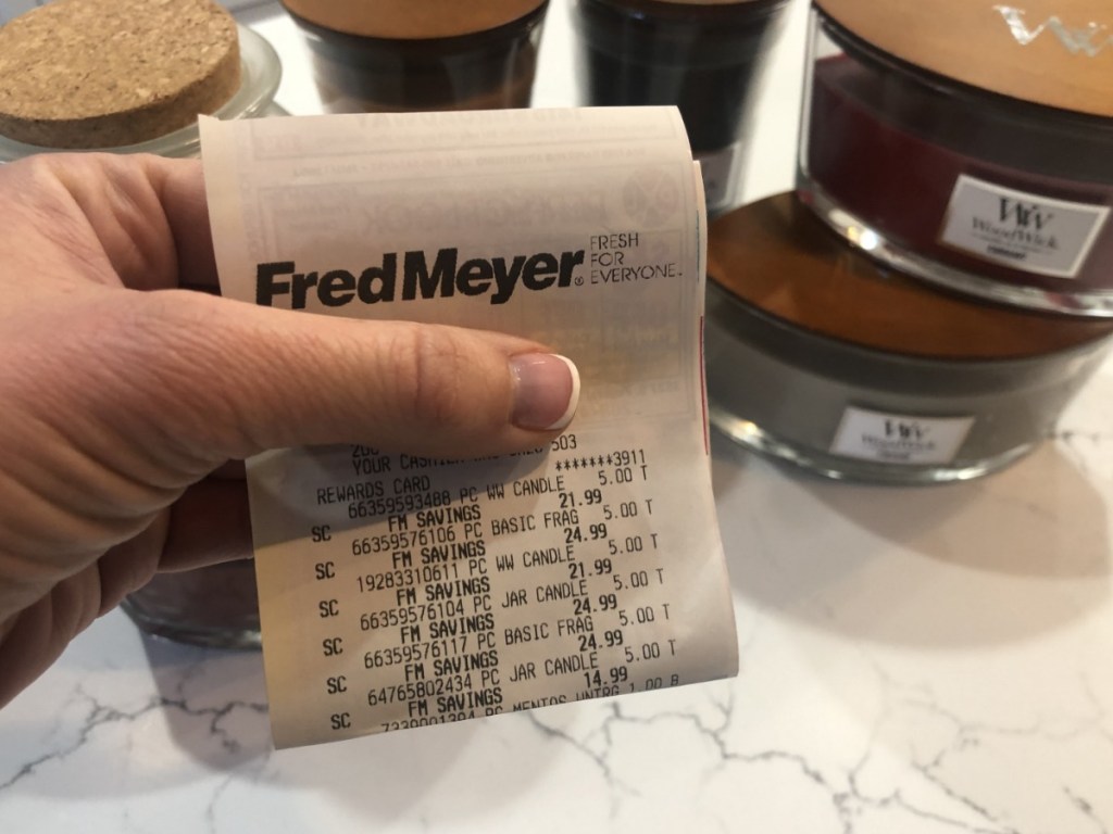 Girl holding fred meyer store receipt showing candle sale