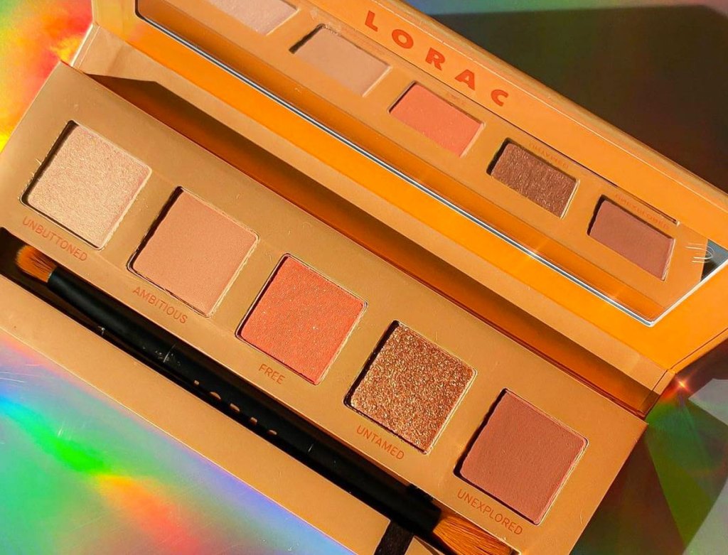 gold toned lorac eyeshadow palette on a holographic background