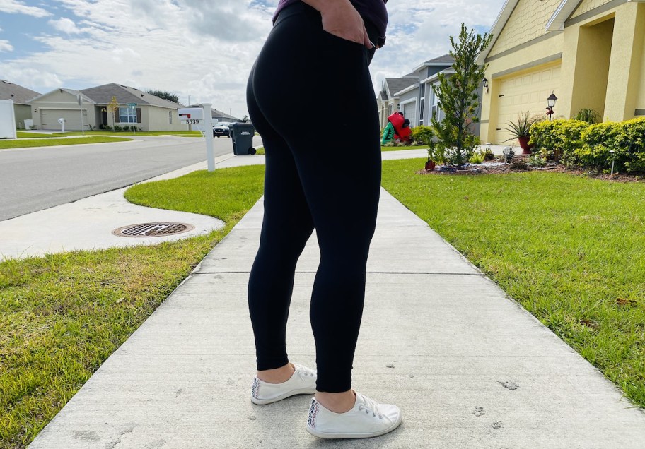 woman wearing black leggings with hand in side pocket