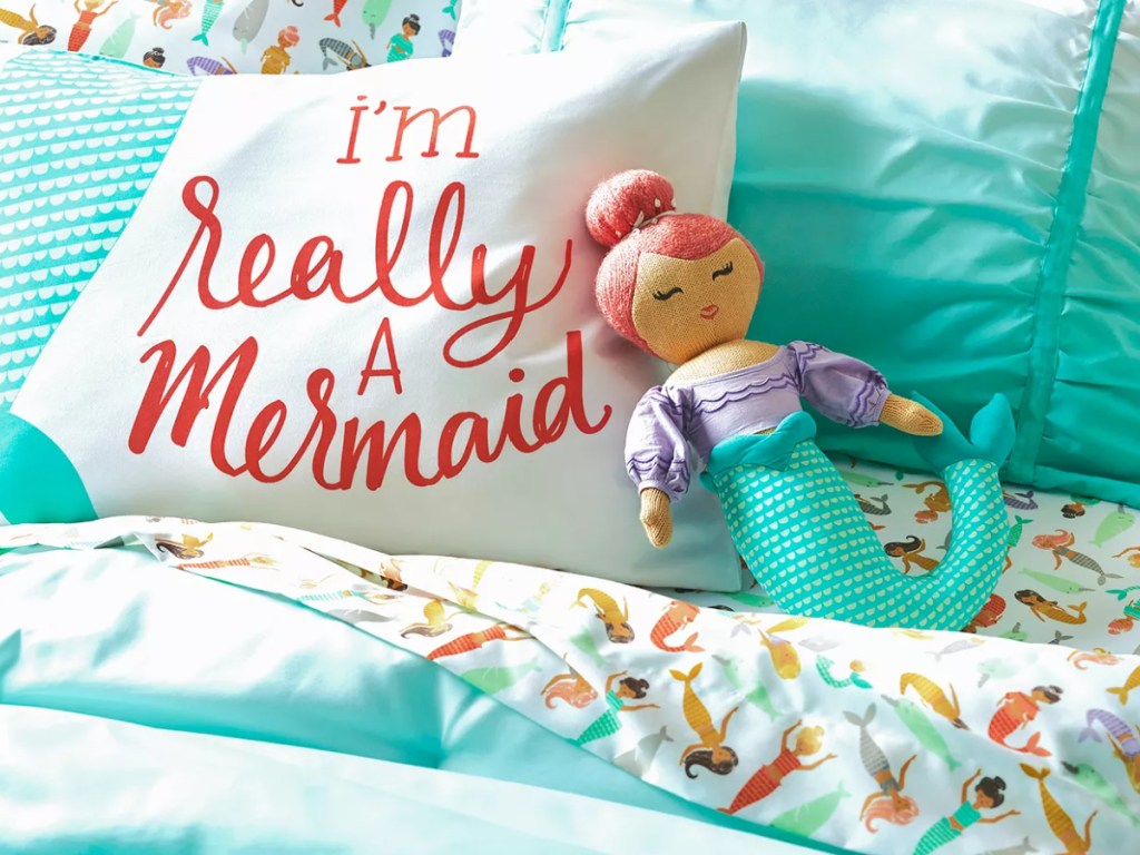 mermaid throw pillows on a child's bed