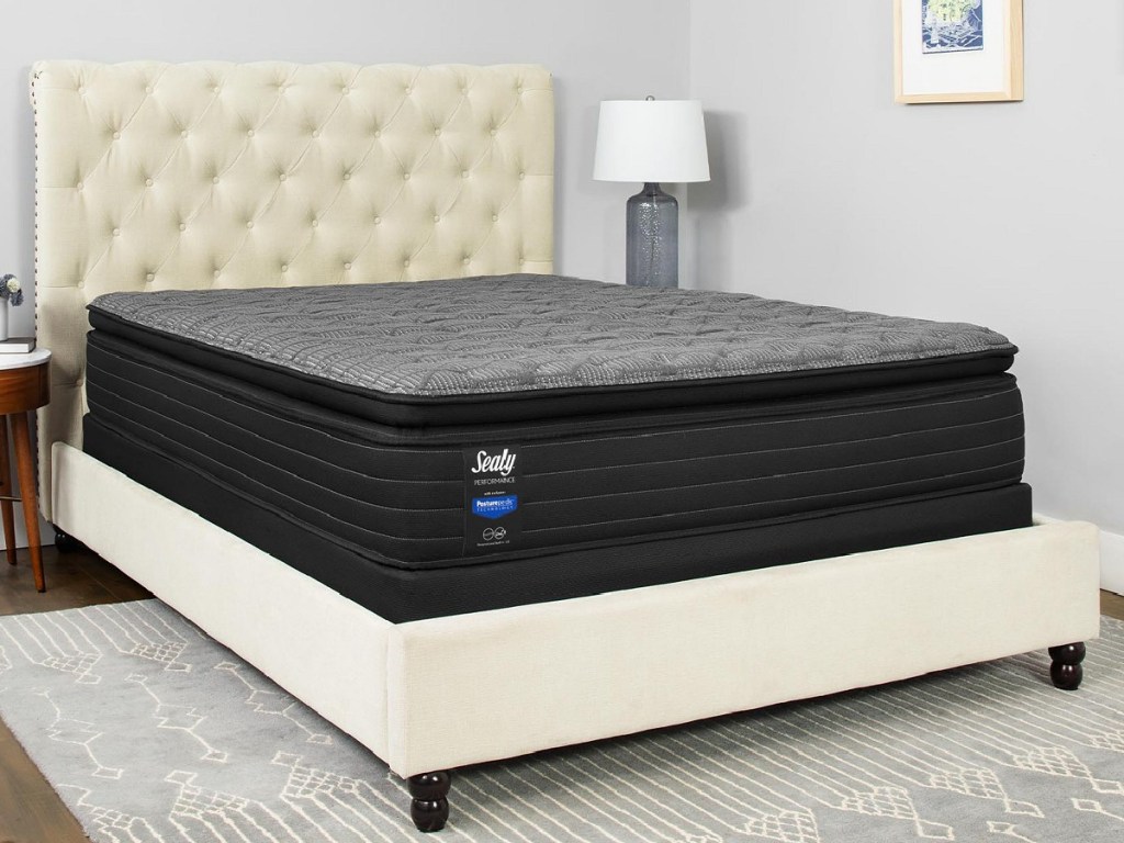 black sealy mattress on a white bed in a bedroom 