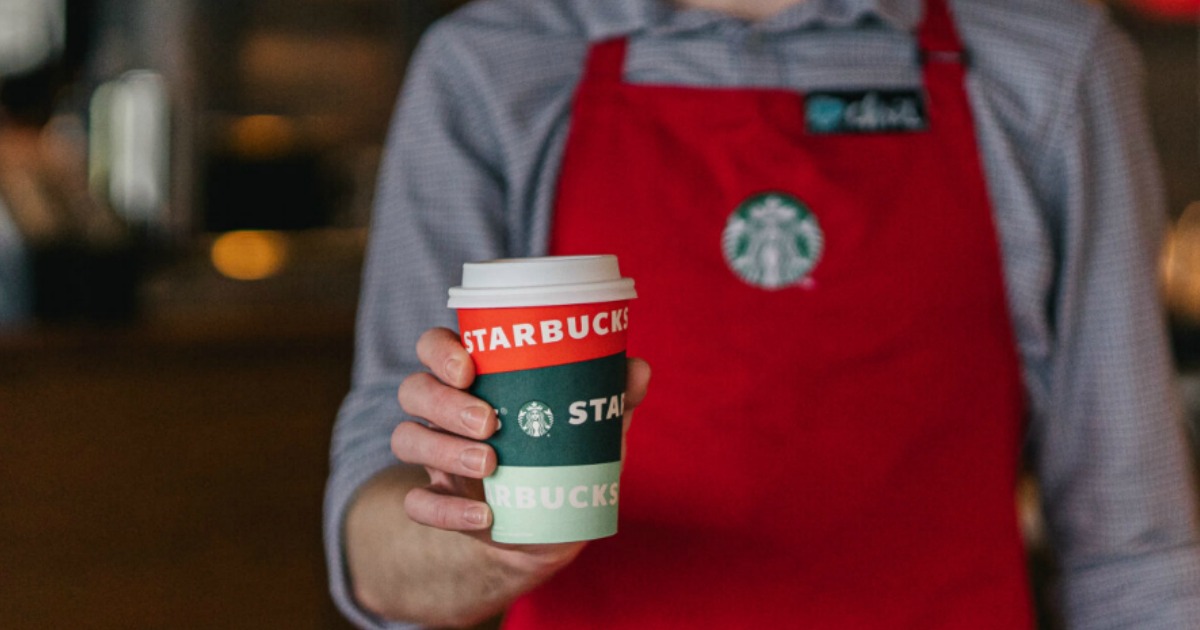 Starbucks employee holding out Starbucks cup - cheap starbucks drinks