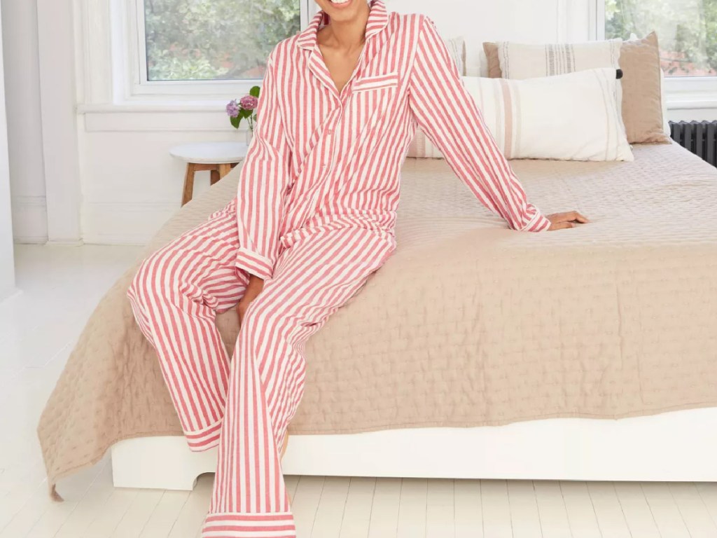 women sitting on a bed wearing red striped flannel pajamas