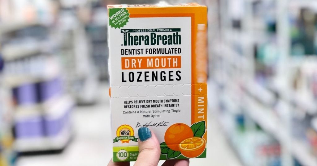 hand holding a box of lozenges