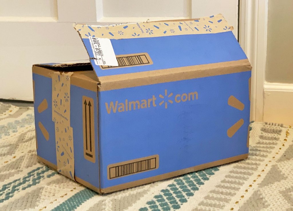 blue walmart.com shipping box on area rug near a door