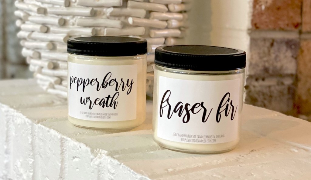 two candles from subscription box on white fireplace