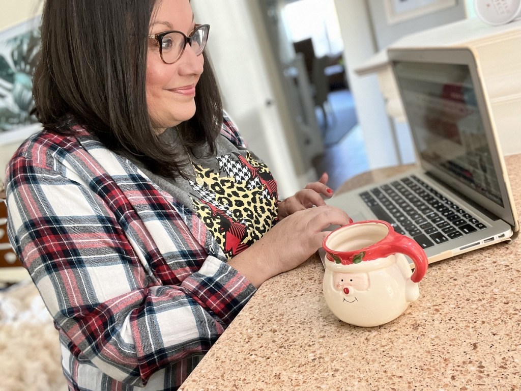 woman with Santa mug using laptop