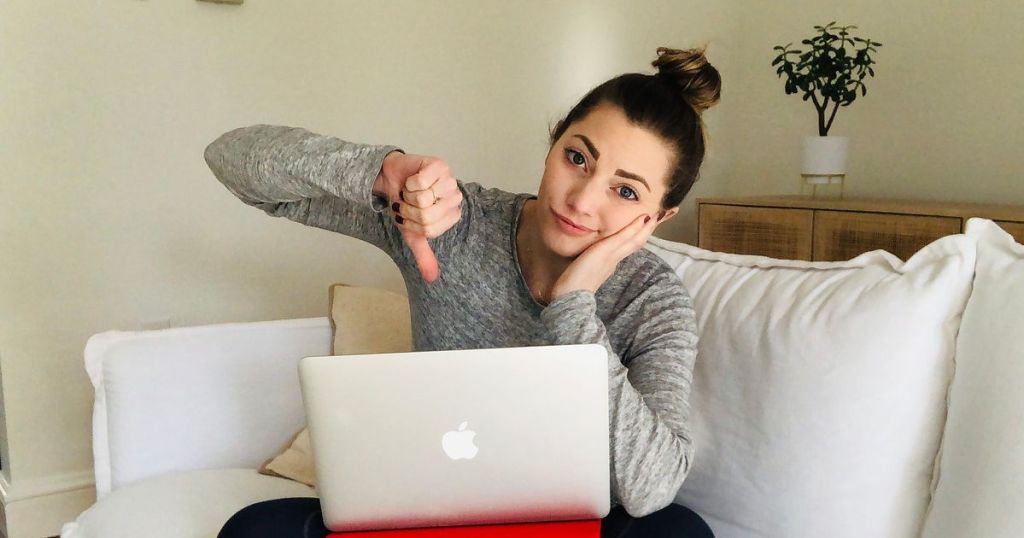 woman with MacBook giving thumbs down