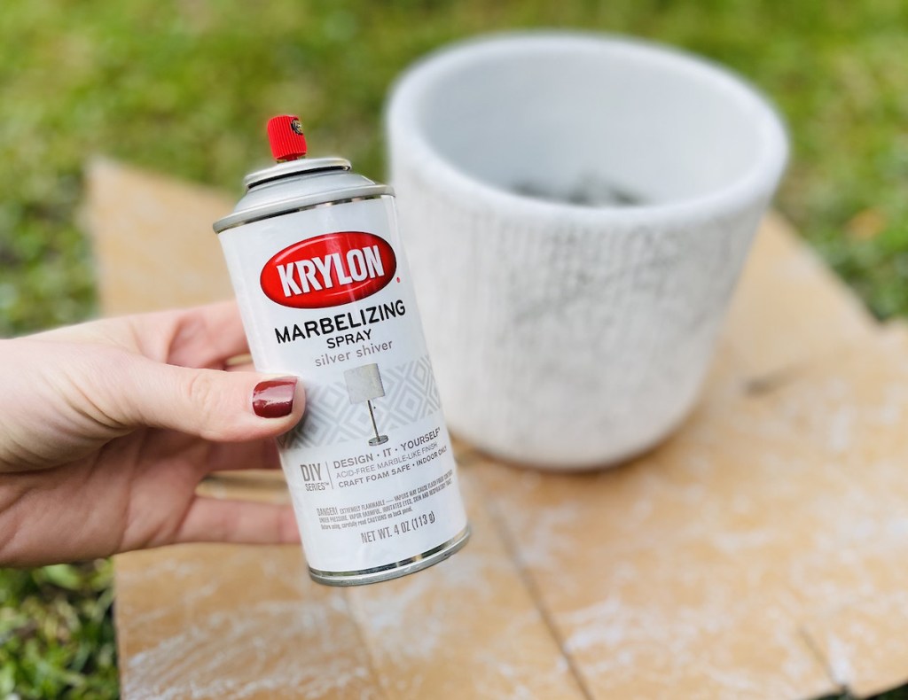 hand holding marble spray paint outside