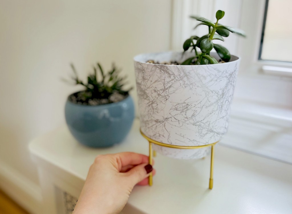 hand holding leg on marble planter