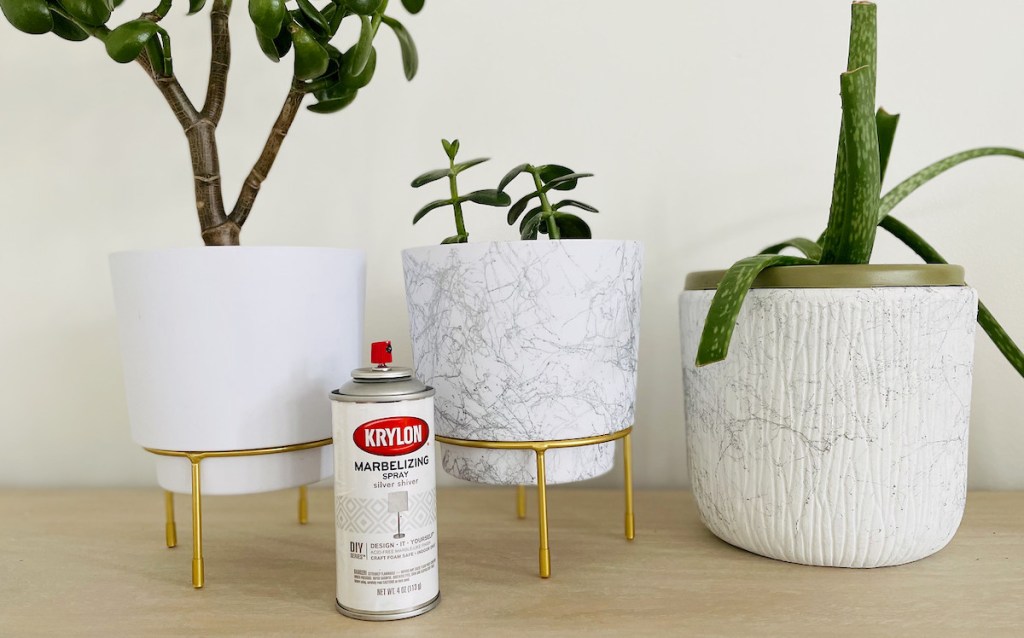 three white and marble planters sitting on table with marble spray paint