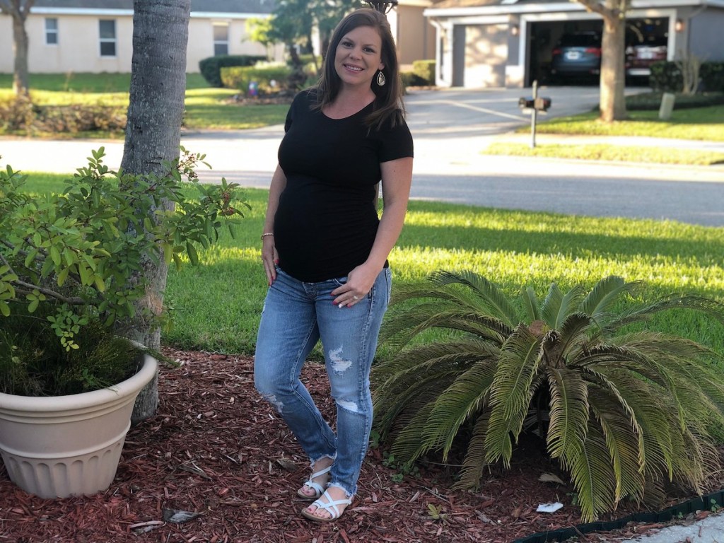 woman wearing maternity jeans and black shirt