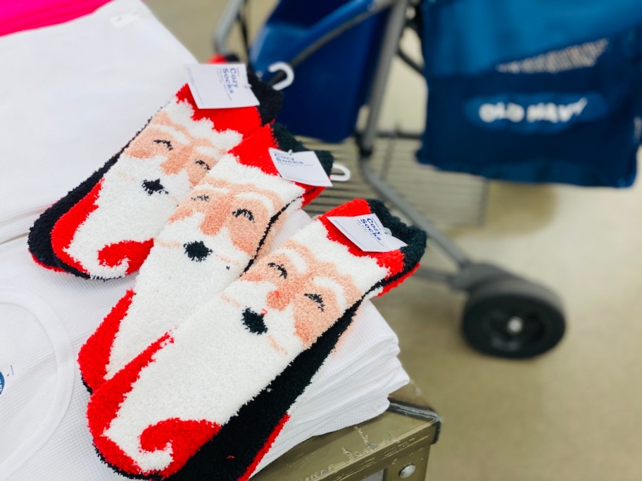 three pairs of santa cozy socks on store counter in old navy