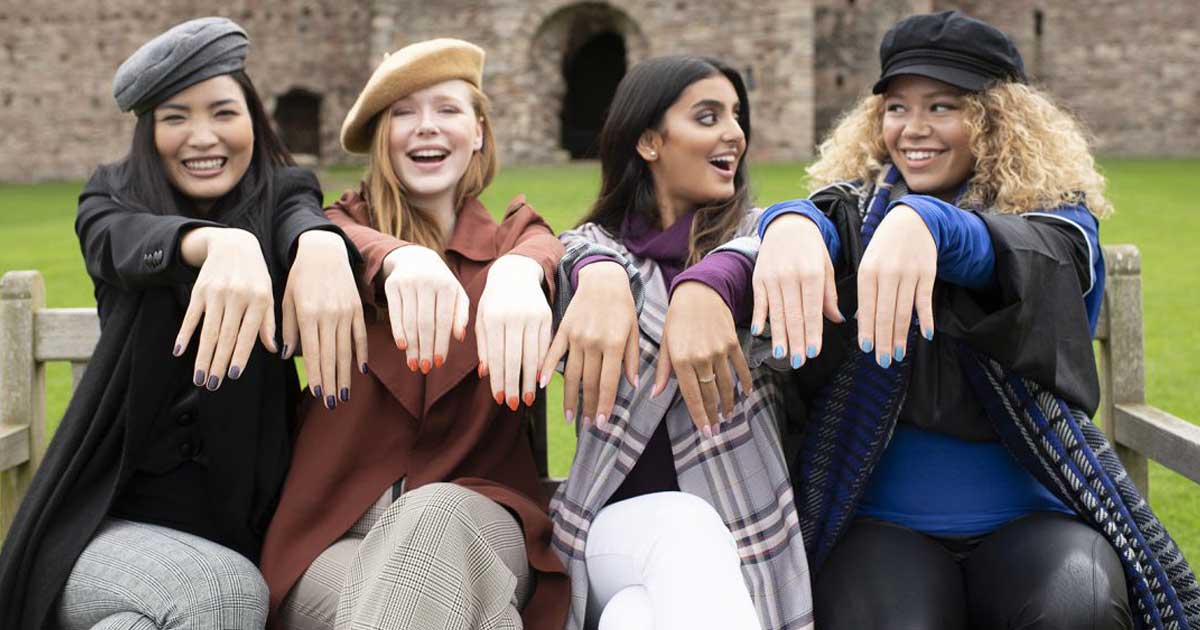 woman sitting in front of castle with hands out in front showing off nails