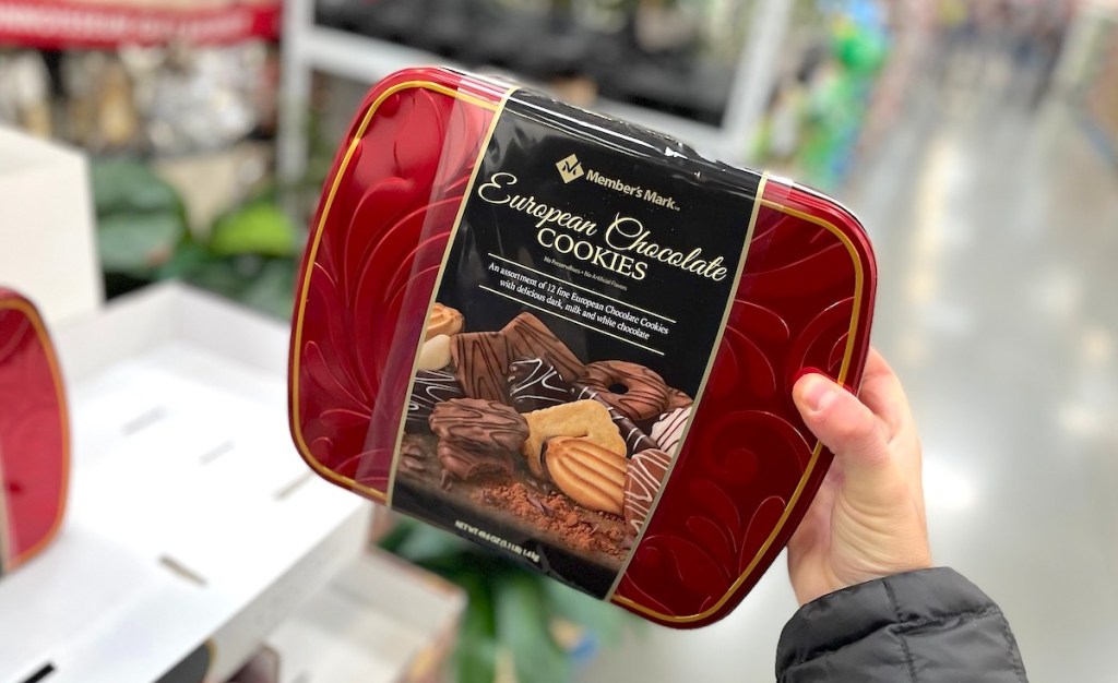hand holding a red tin of members mark european cookies
