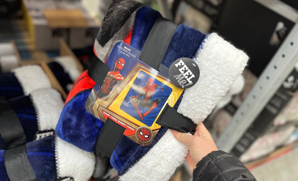hand holding a spider man throw blanket in store aisle