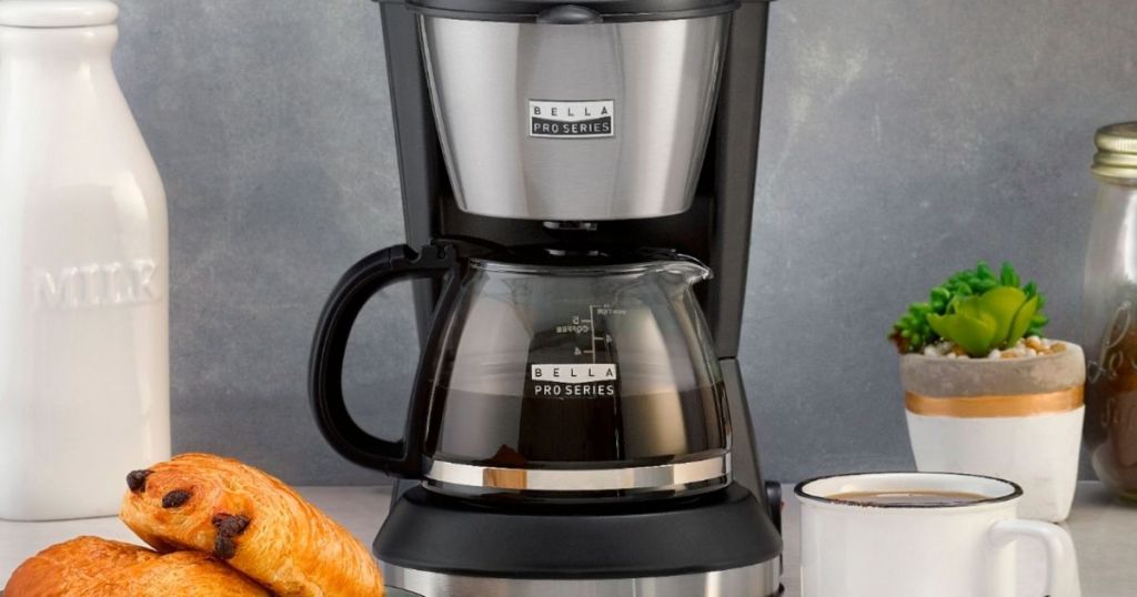 coffee maker with cup and scones by it