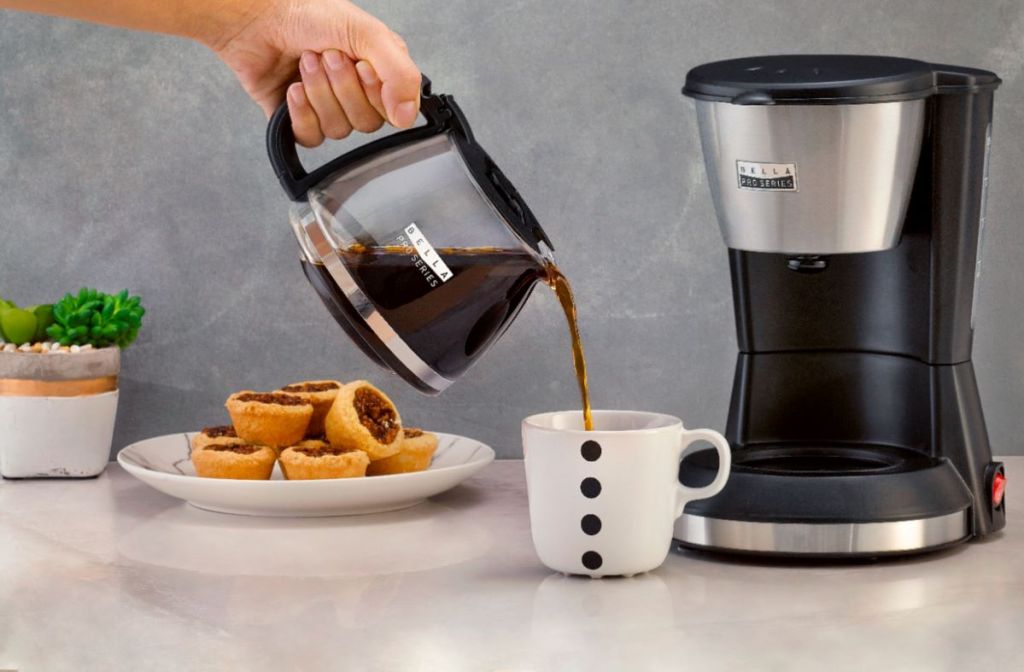 hand pouring coffee into a cup