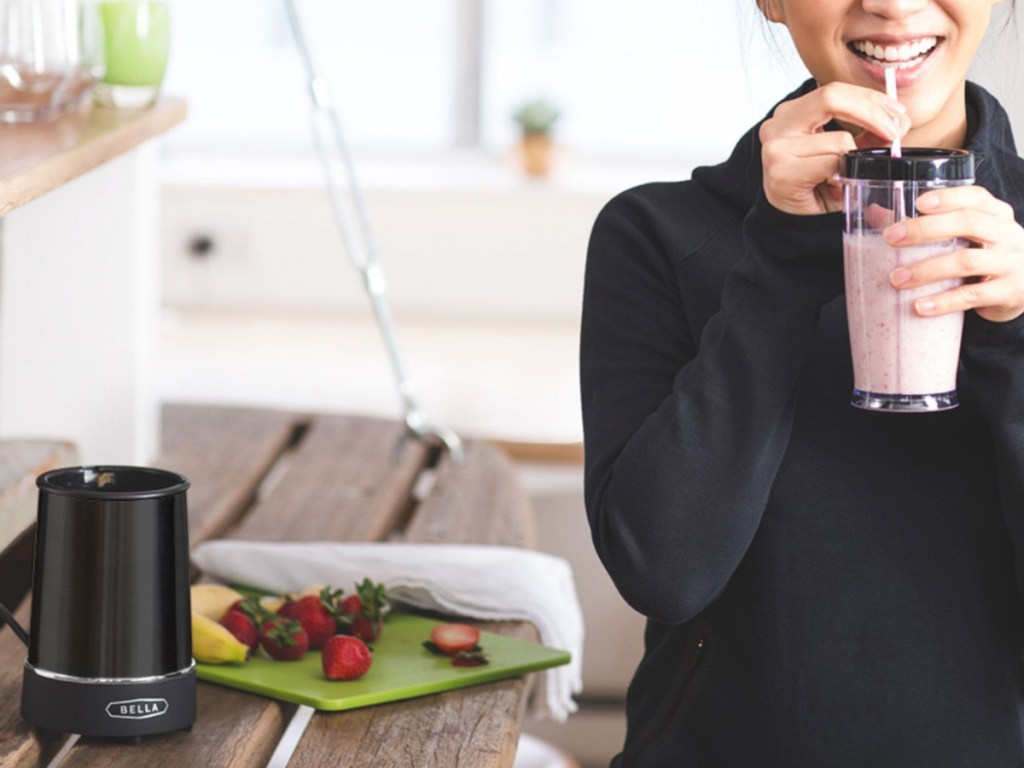 woman holding a blender smoothie cup