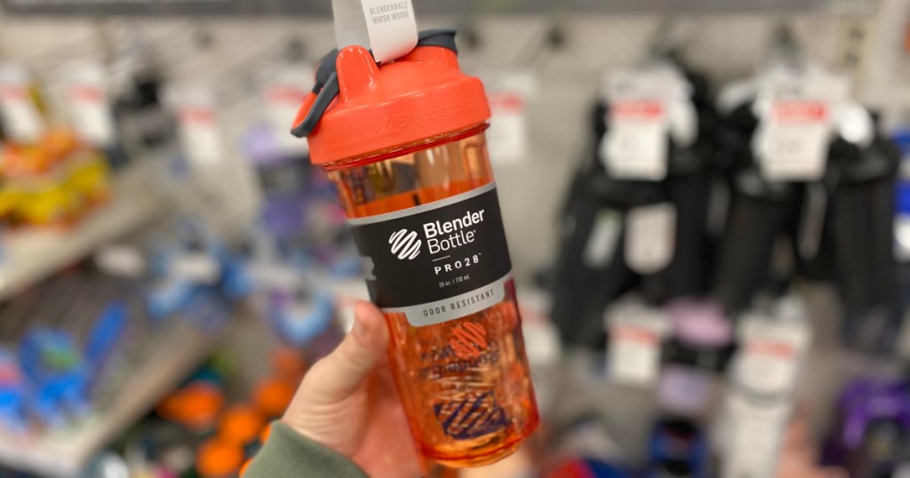 hand holding orange blender bottle