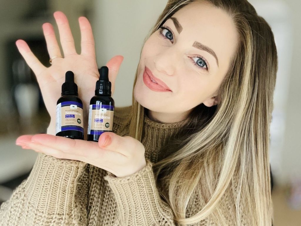 woman holding two bottles of eldberry