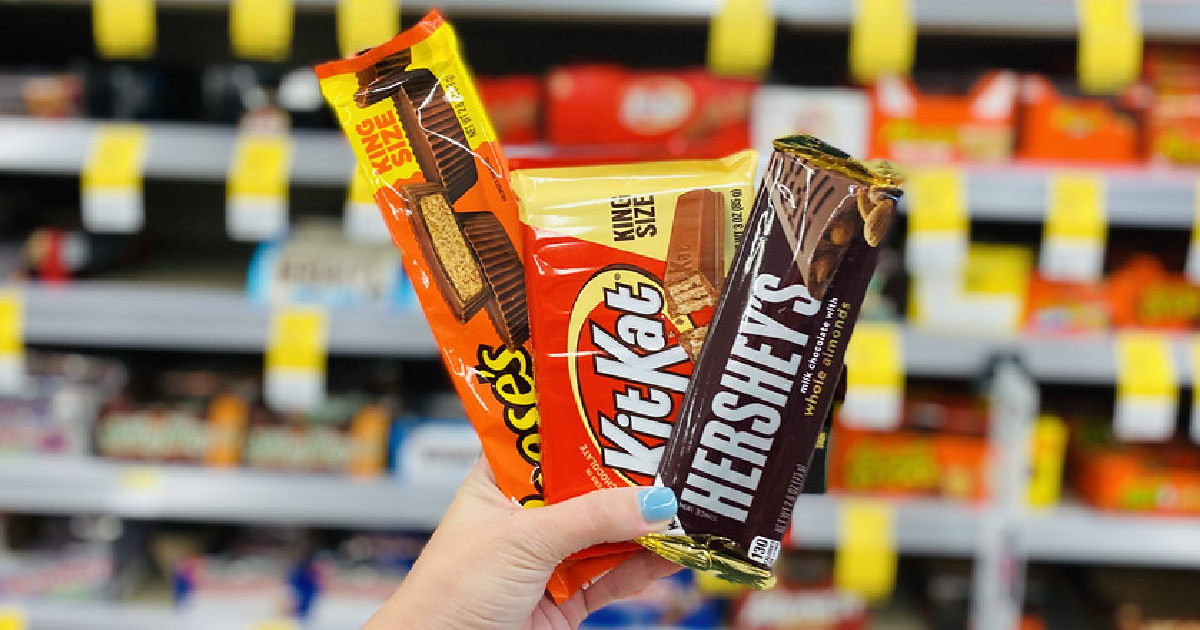 woman's hand holding three Hershey's candy bars