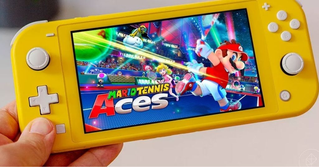 hand holding yellow nintendo switch lite with Mario Tennis Aces for Nintendo Switch on screen