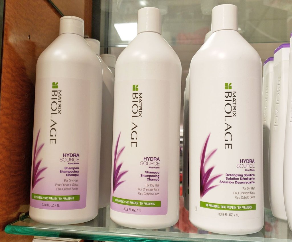 large bottles of matrix biolage shampoo and conditioner on glass display shelf