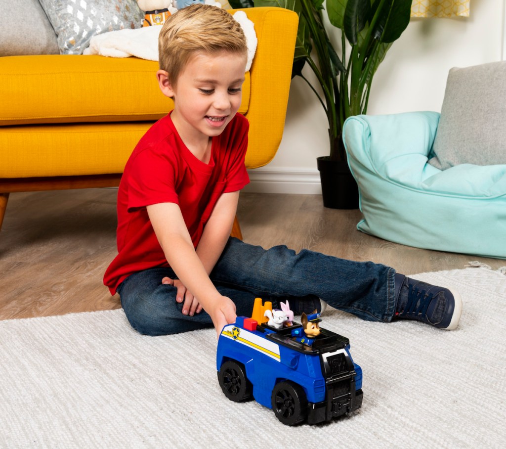 boy playing PAW Patrol Chase’s Ride ‘n’ Rescue Transforming 2-in-1 Playset and Police Cruiser
