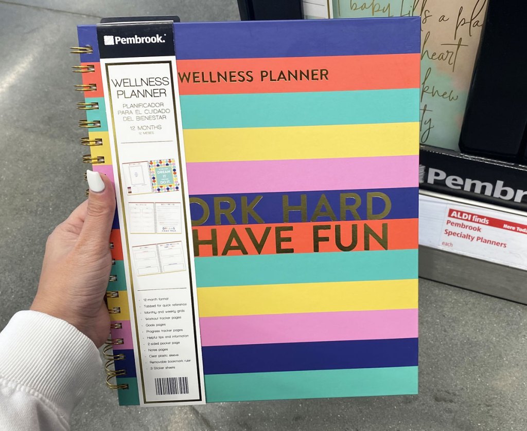 woman holding up multi-color striped 12-month wellness planner