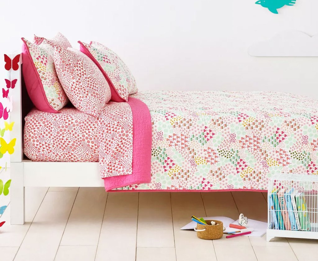 pink printed quilt on a kids bed