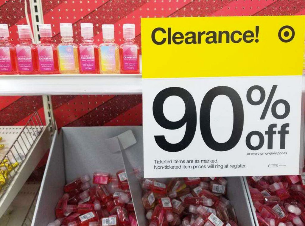 small holiday hand sanitizers on a target shelf with a yellow and white 90% off clearance sign